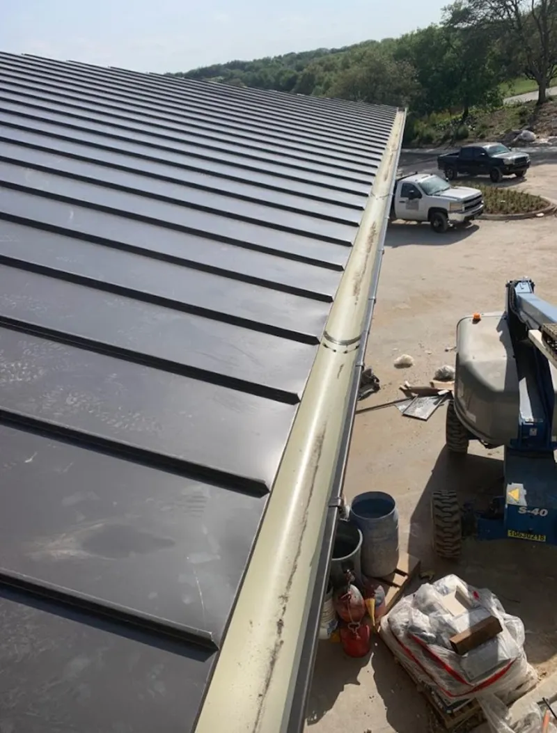 Standing seam panel and gutter detail on a metal roofing jobsite in Augusta